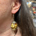 Brown Quail Egg Earrings hanging on a woman's ear